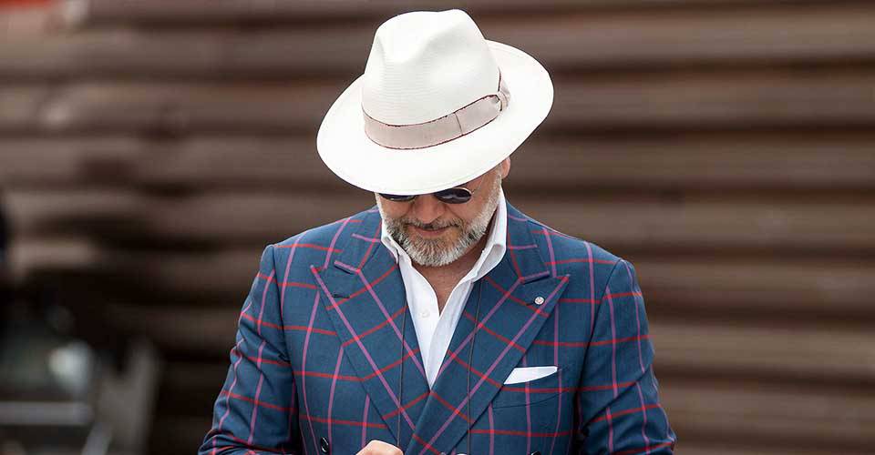 身著灰藍色格紋西裝外套搭白色帽子的大叔