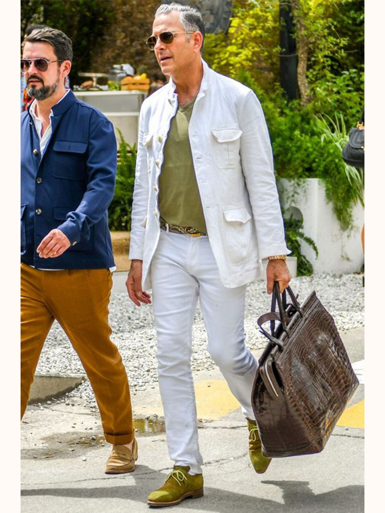 穿著經典白色襯衫外套並提著公事包的男子