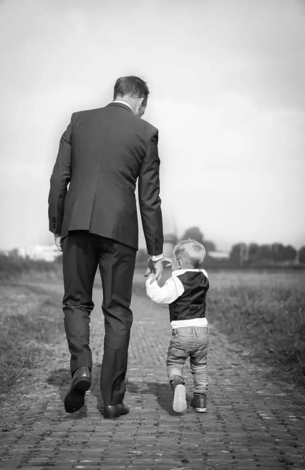 穿著西服的父親與小孩的背影