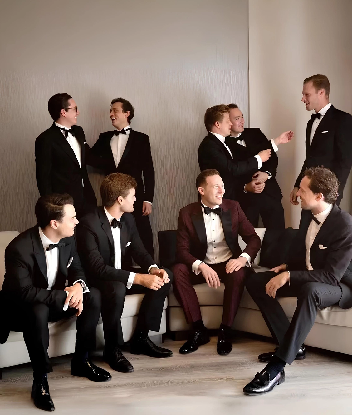 身著酒紅色結婚西裝的新郎與身著黑色西裝的伴郎團