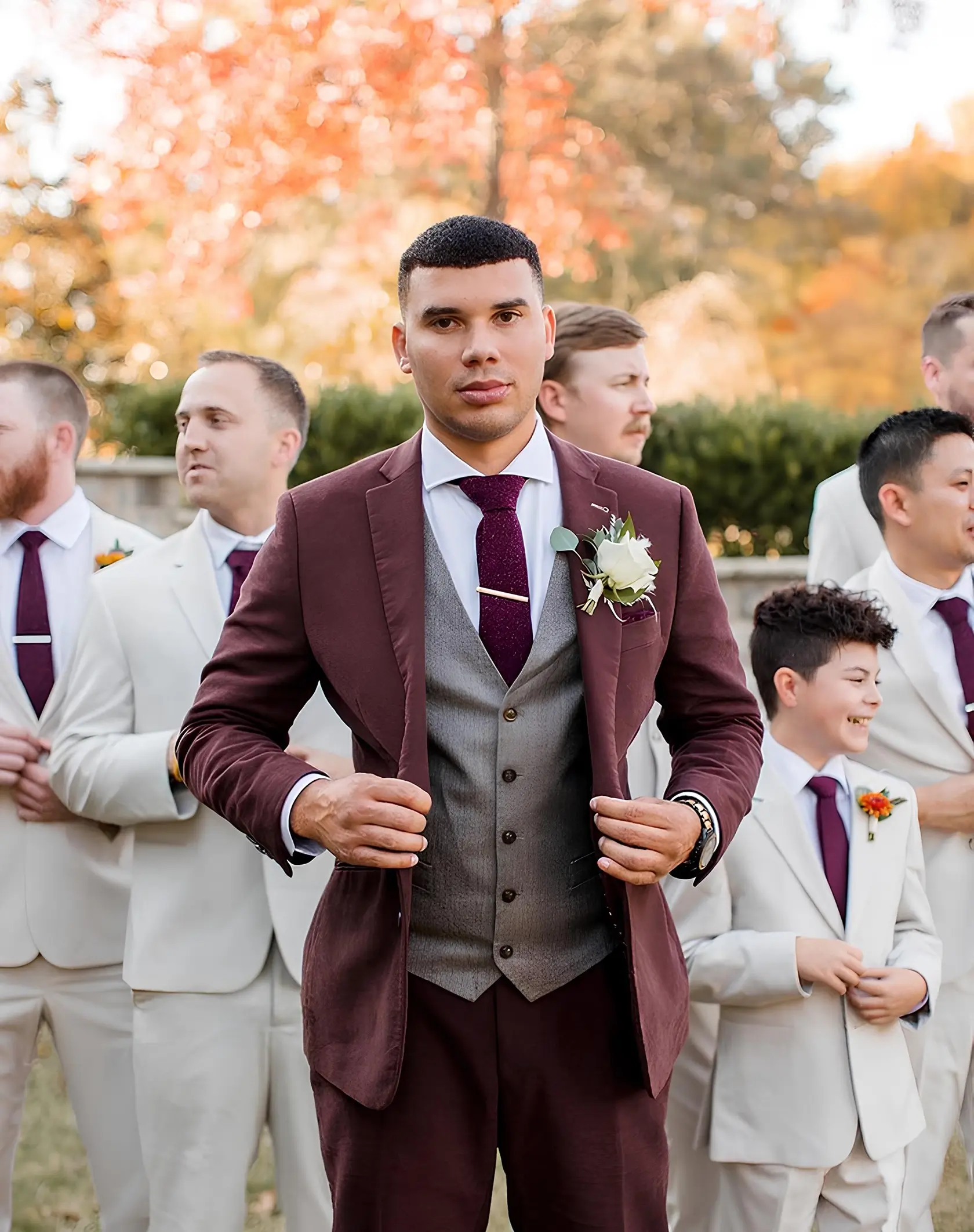 穿著紅色西裝搭配灰色西裝背心的新郎