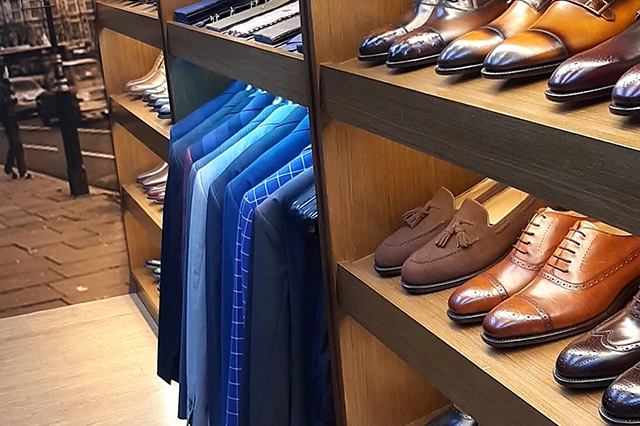 力群男士西裝店內展示的眾多西裝與皮鞋